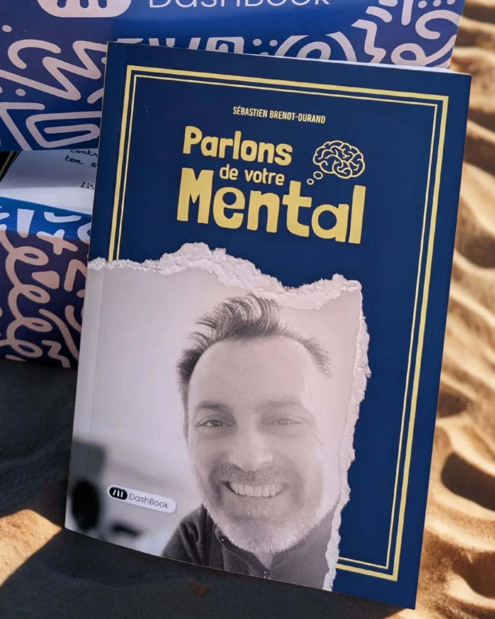 Le livre Parlons de votre Mental posé sur le sable